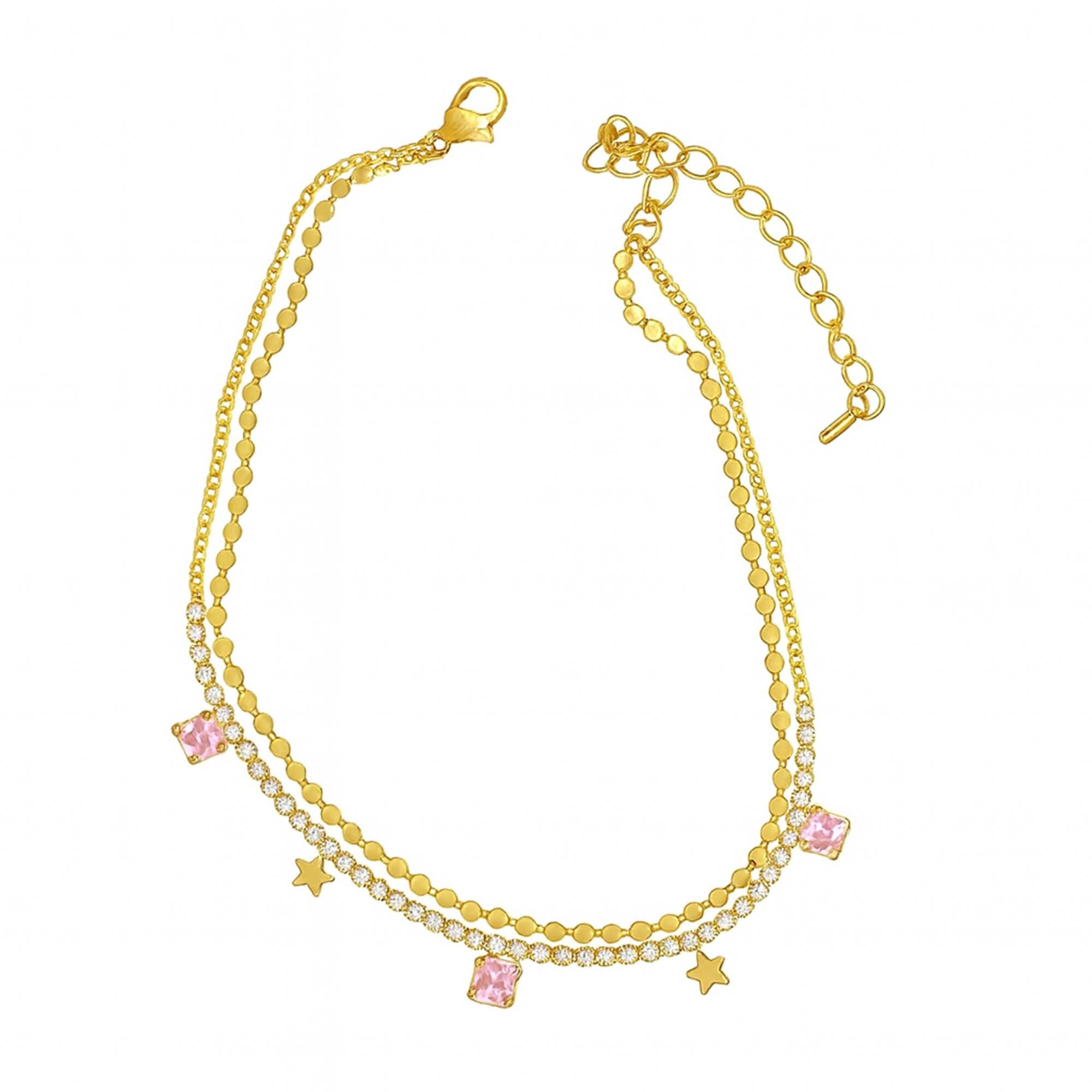 Gold anklets with pink and clear gemstones on a white background