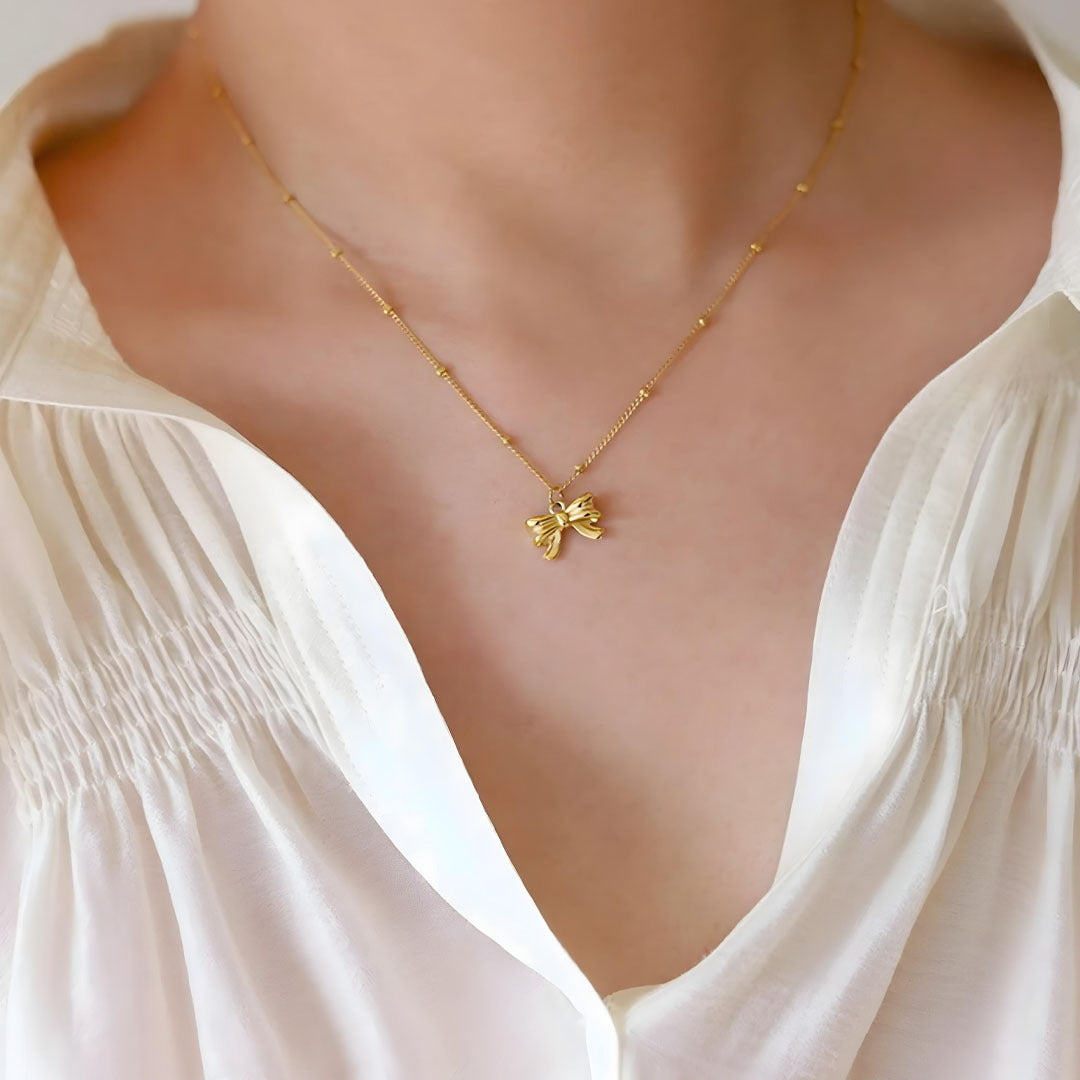 Gold necklace featuring a bow-shaped pendant