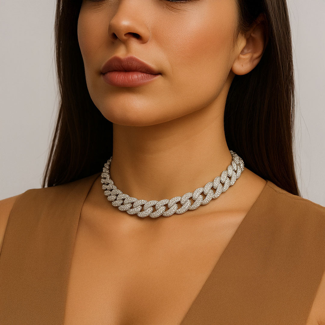 Close-up of a woman wearing a diamond necklace against a neutral background