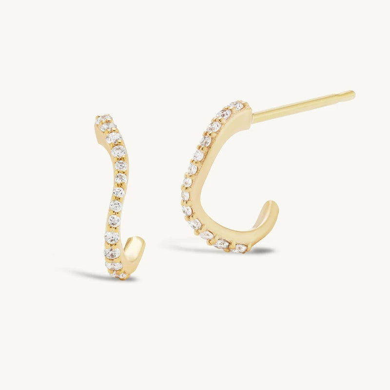 Gold hoop earrings with clear gemstones on a white background