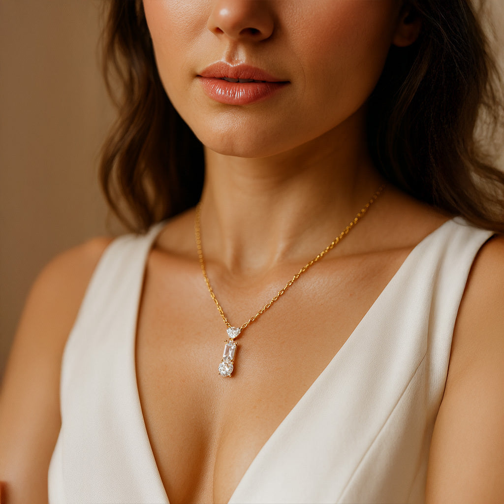 Close-up of a woman wearing a gold necklace with a diamond pendant.