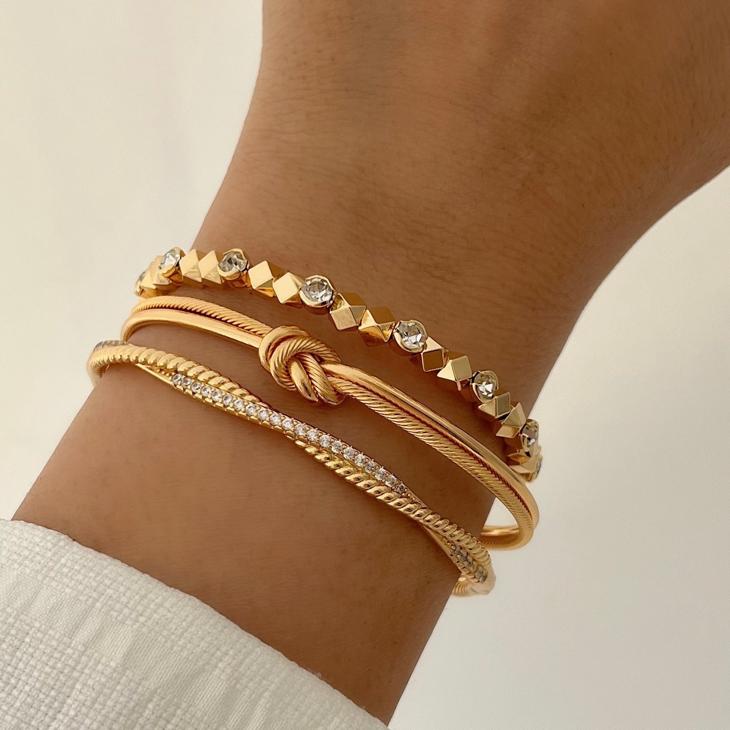 Gold bracelet stack for women with crystal stud bracelet, knot bangle and slim chain bracelet