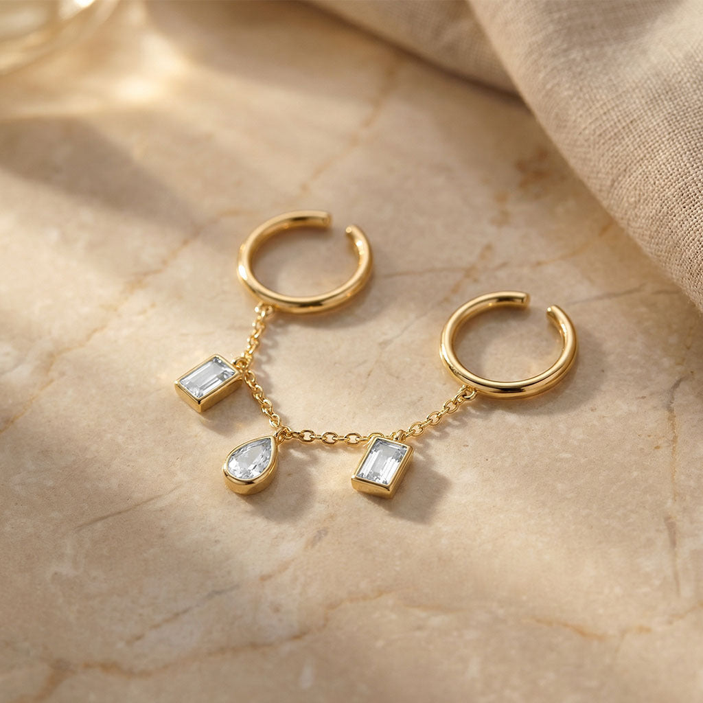 hand shot featuring a gold connected ring design with chain detailing and sparkling stone charms.