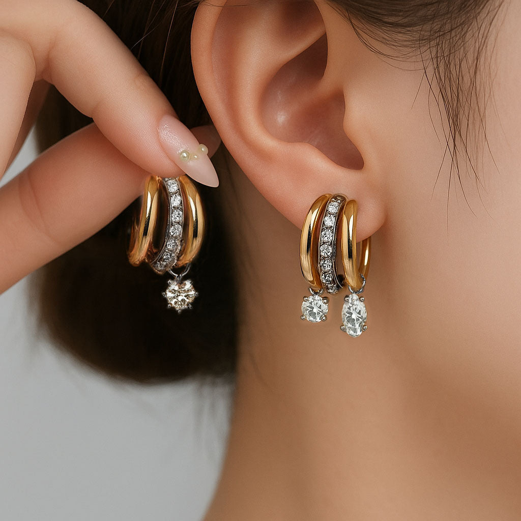 Gold hoop earrings with gemstones worn by a person