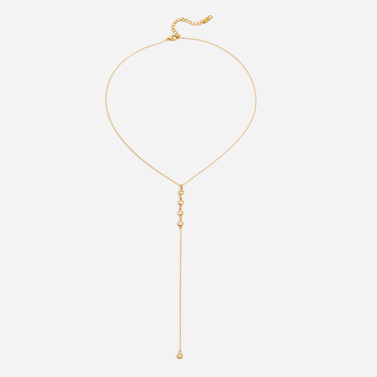 Gold lariat necklace on a white background