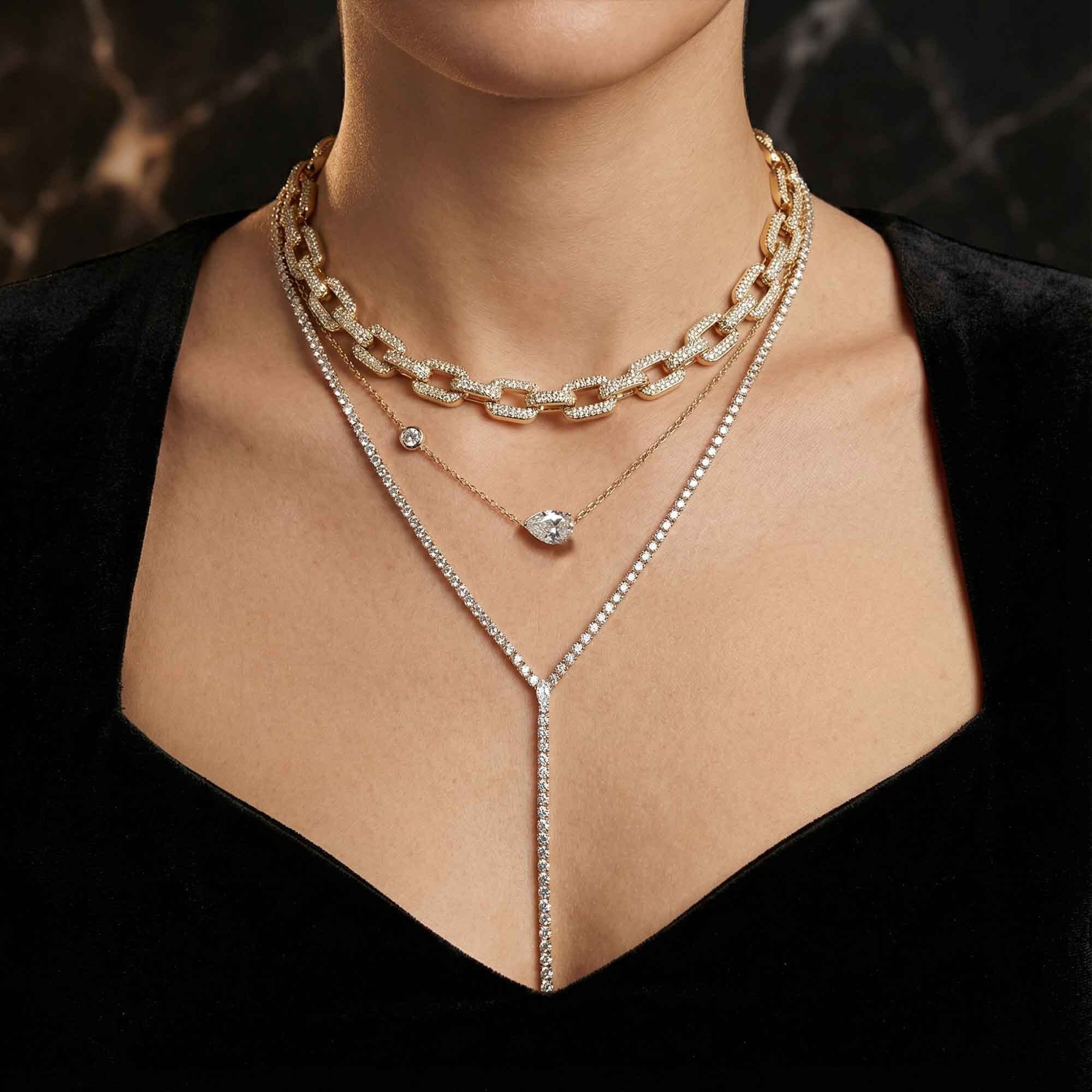 Close-up of a person wearing multiple necklaces with a dark background