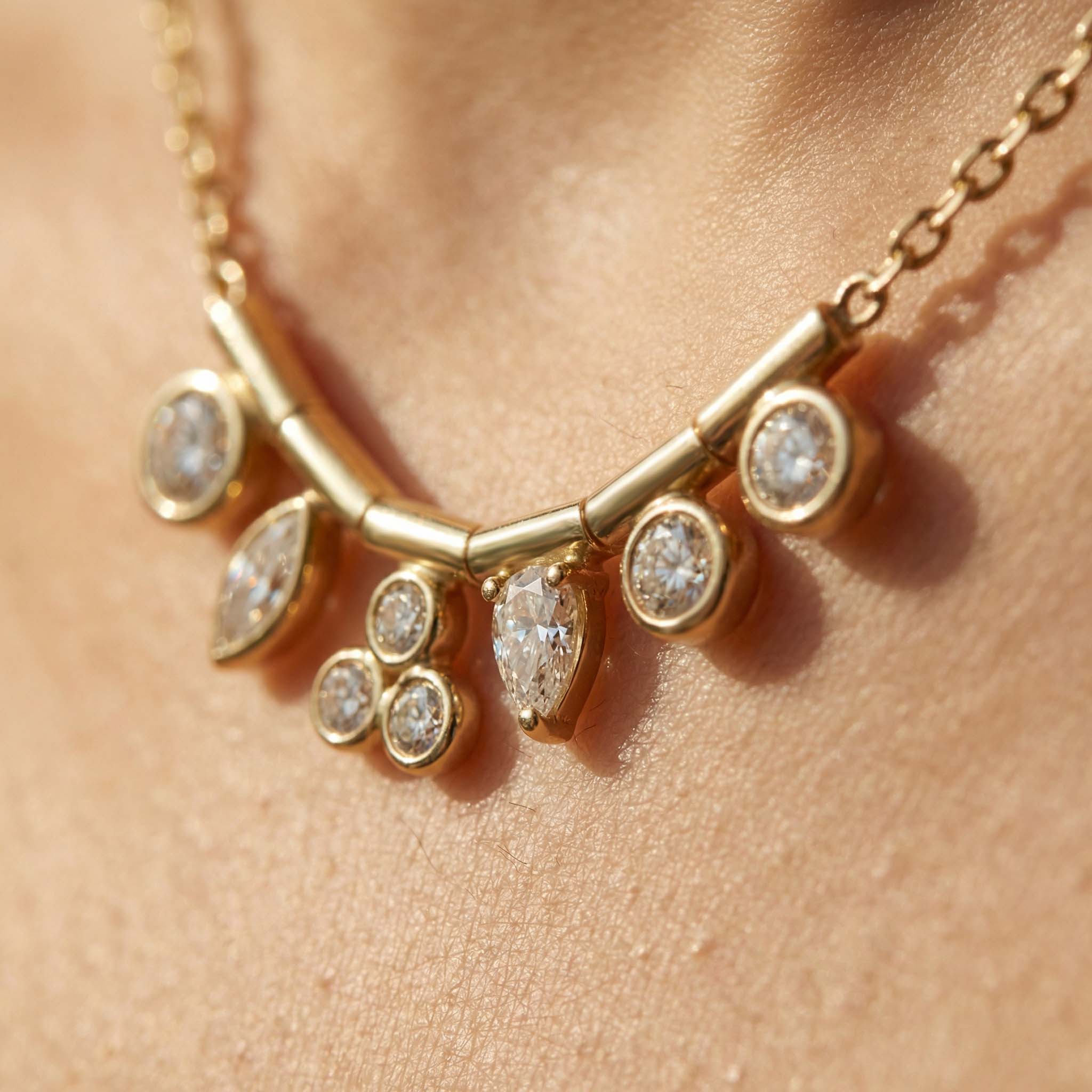 Gold necklace with diamond-like stones on a person's neck