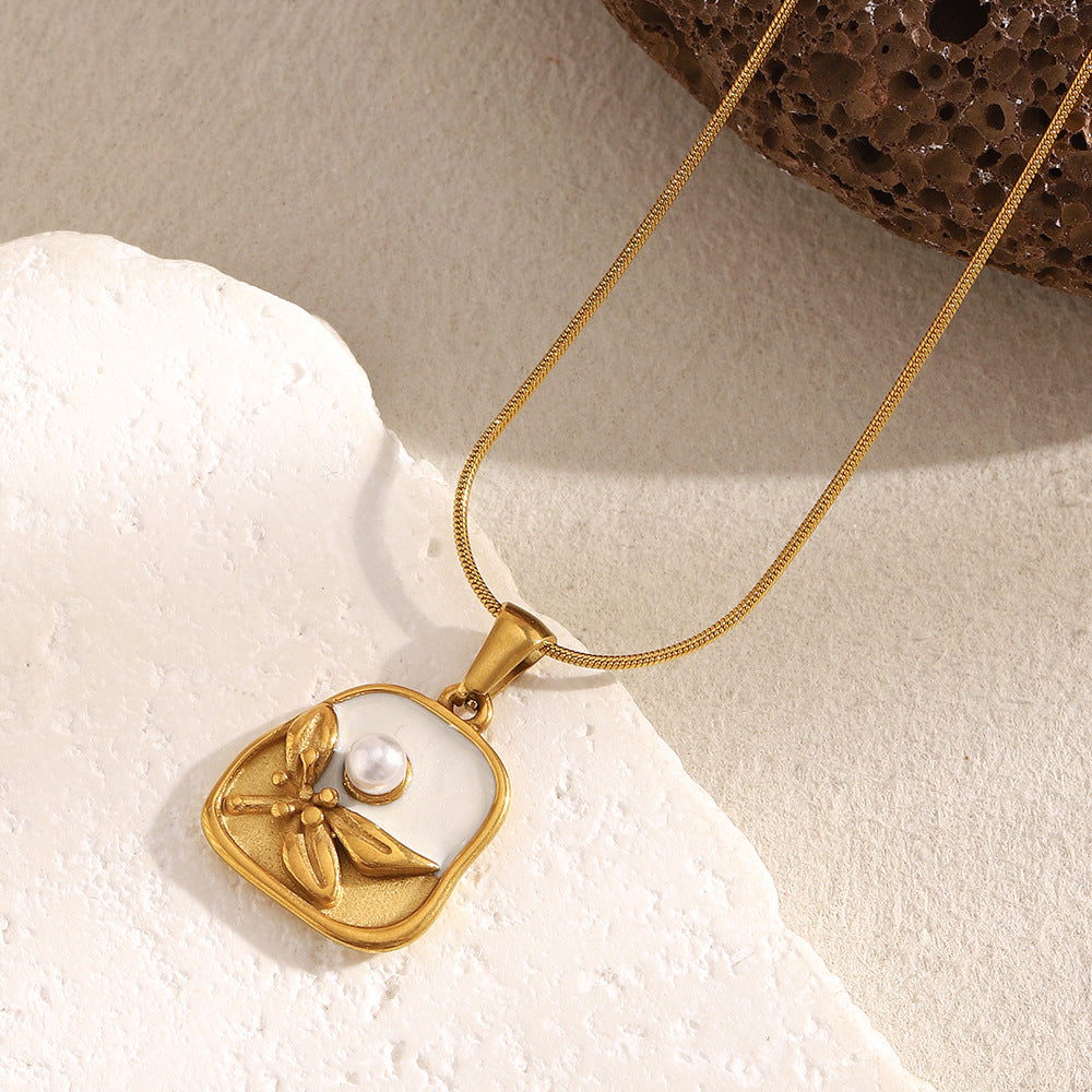 Gold necklace with a pendant  neckalce for women featuring a butterfly and pearl on a textured surface.