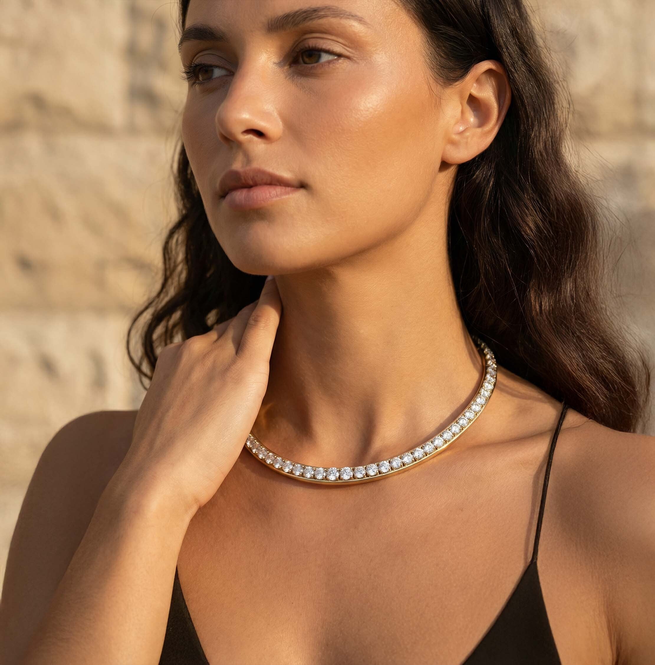 Woman wearing a diamond necklace against a neutral background
