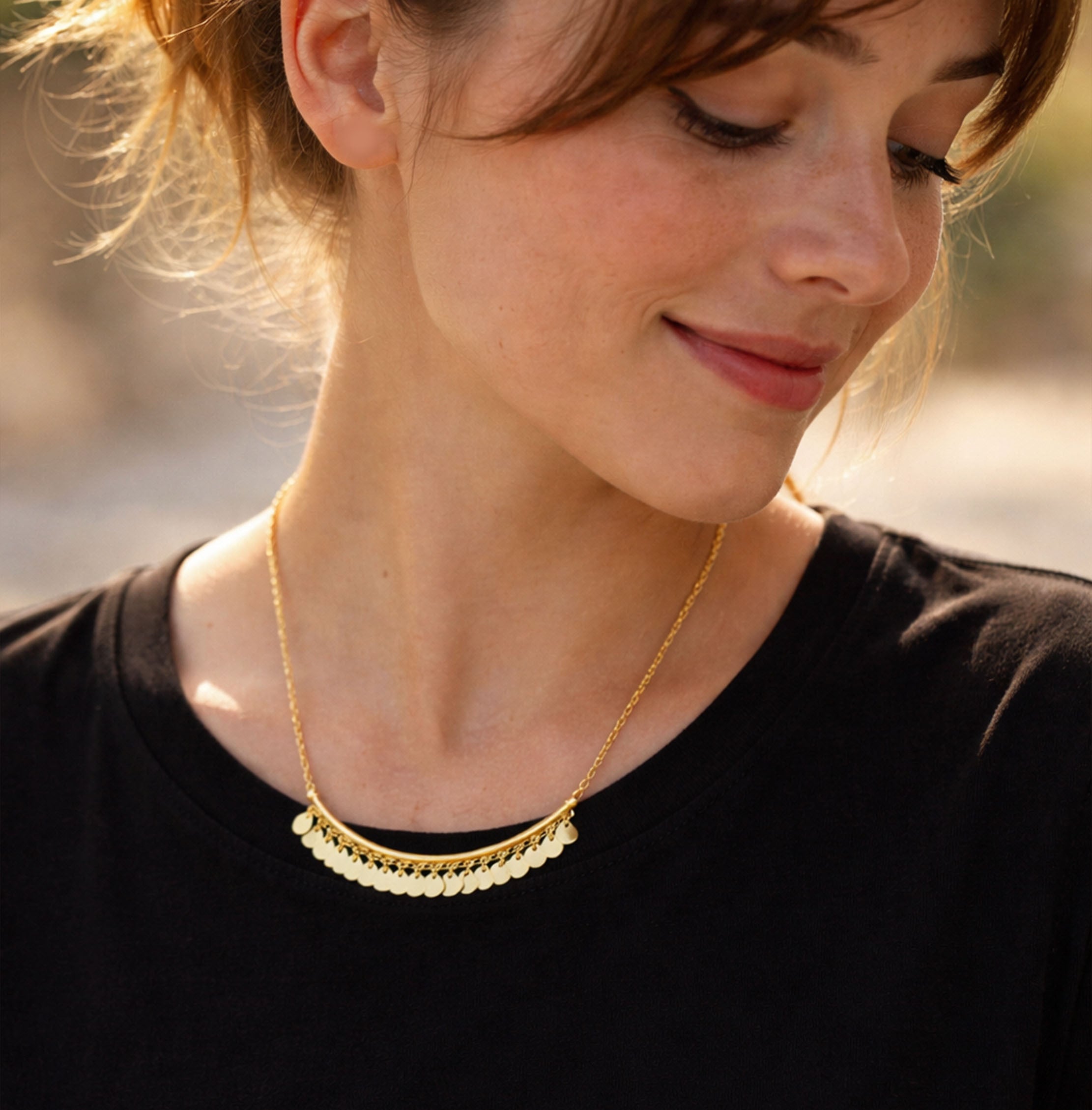 Woman wearing a gold necklace for women with a blurred background