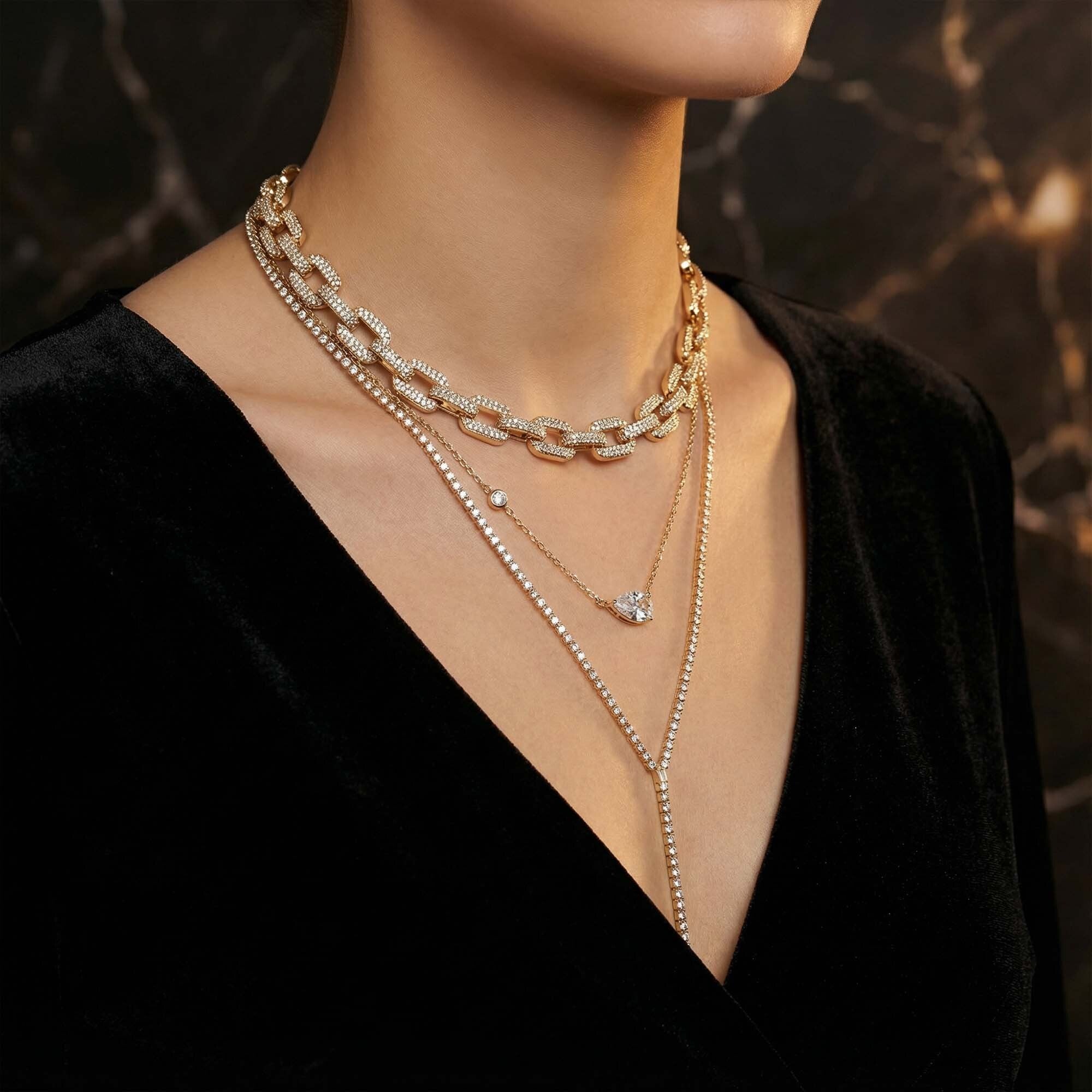 Close-up of a person wearing multiple gold necklaces for women on a dark background