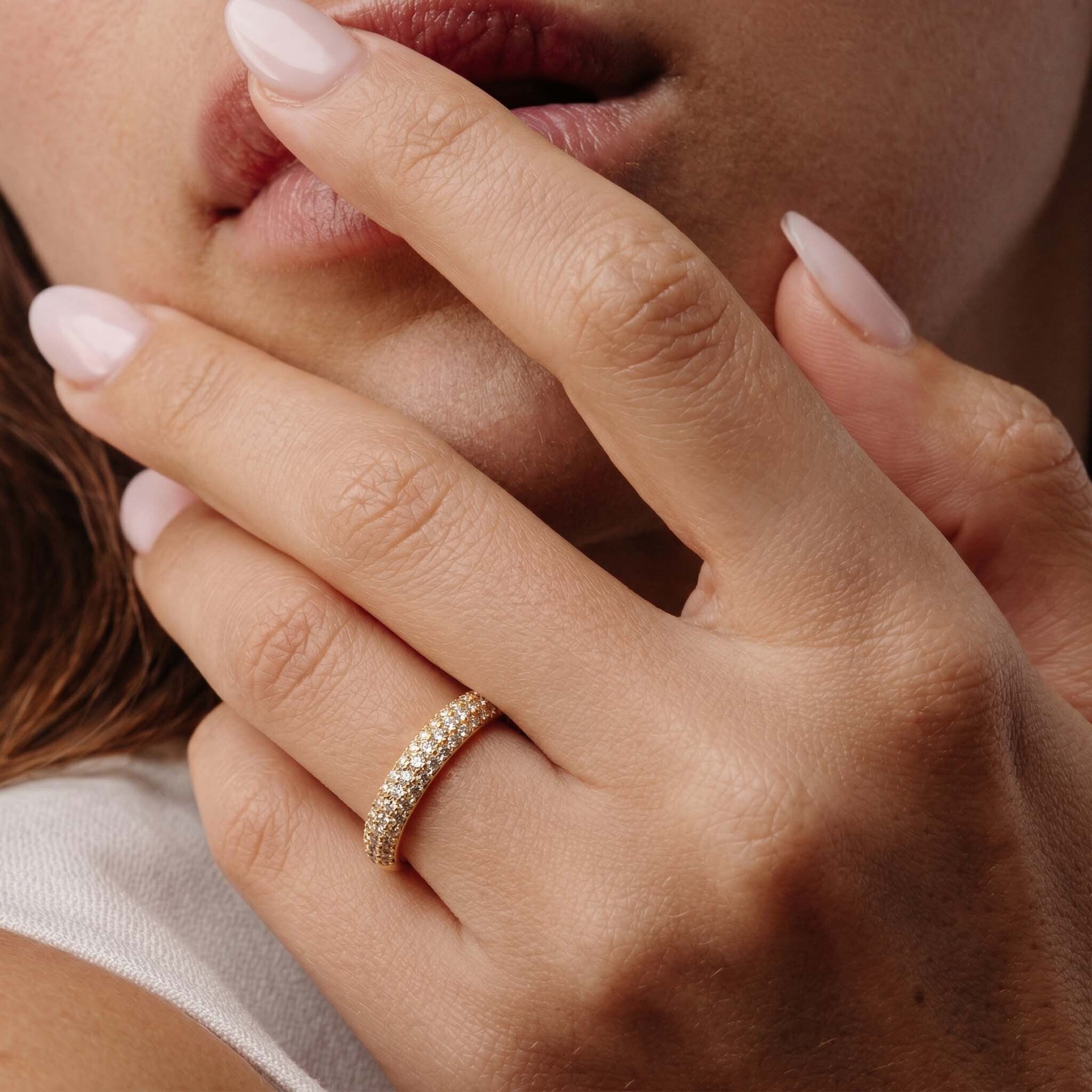 Woman’s hand adorned with a sparkling gold ring, ideal for evening occasions and everyday elegance.