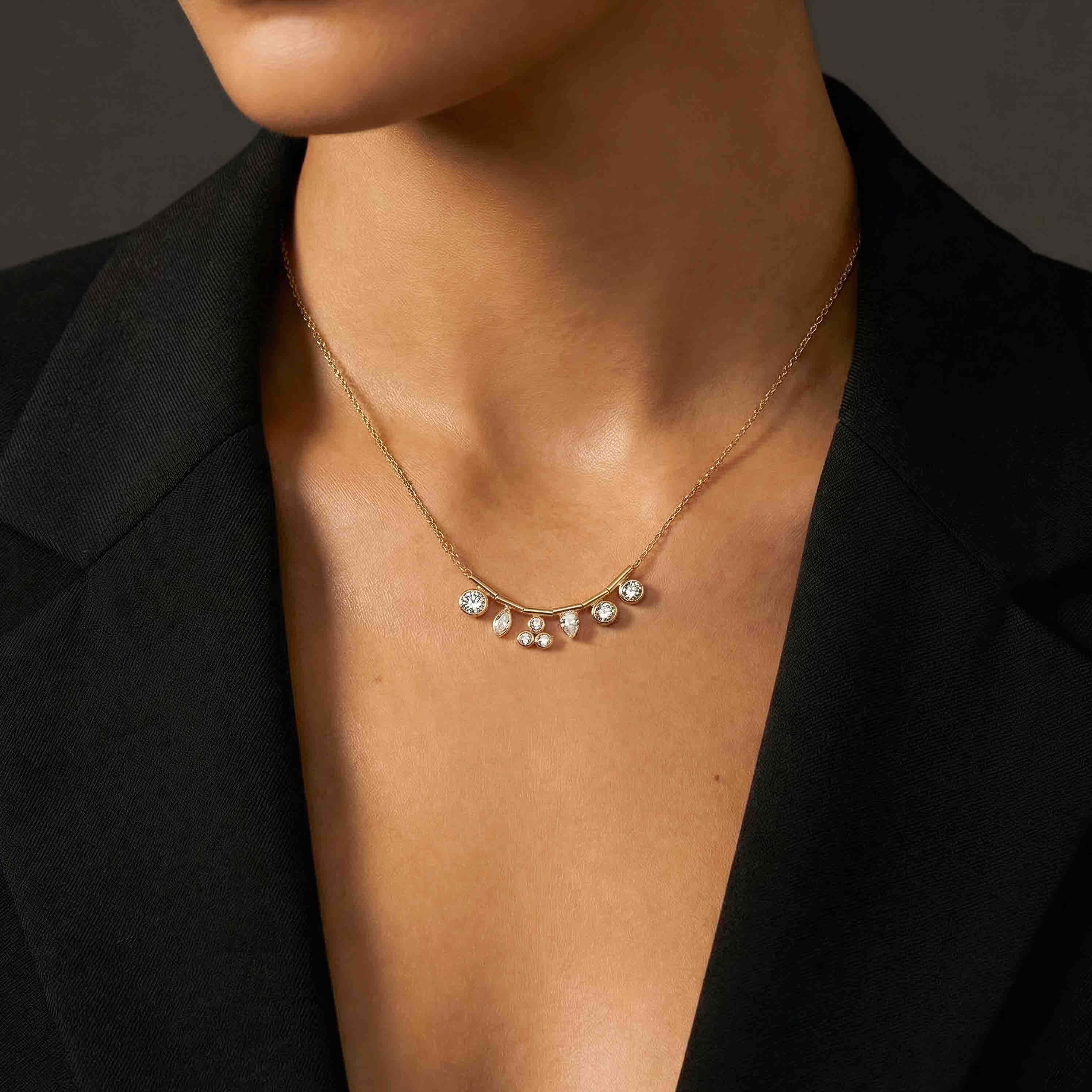 Necklace with small pearls worn by a person against a dark background