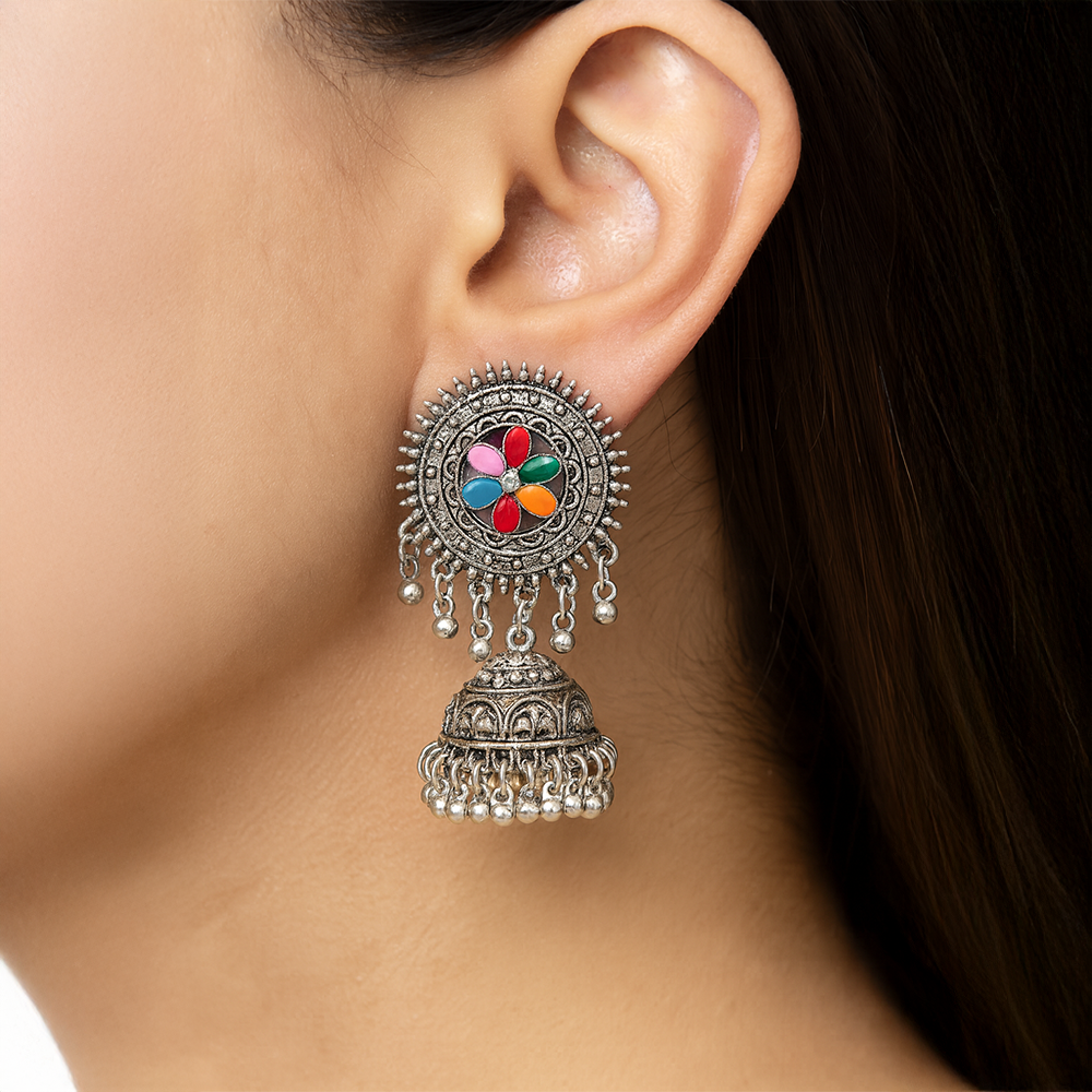 Close-up of an ear wearing a decorative silver earrings for women with colorful stones.