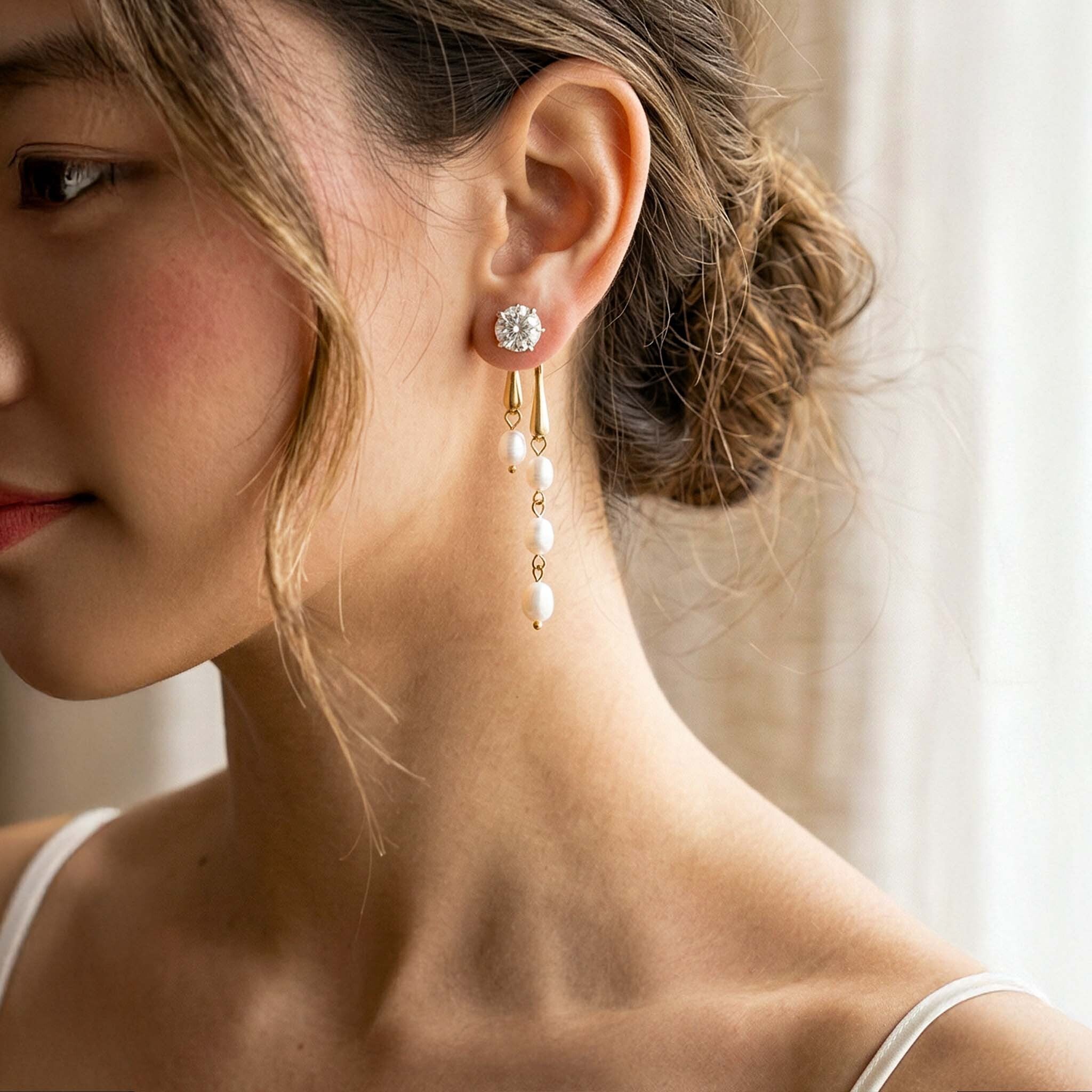 Gold drop earrings for women with pearl beads and crystal stud worn by woman