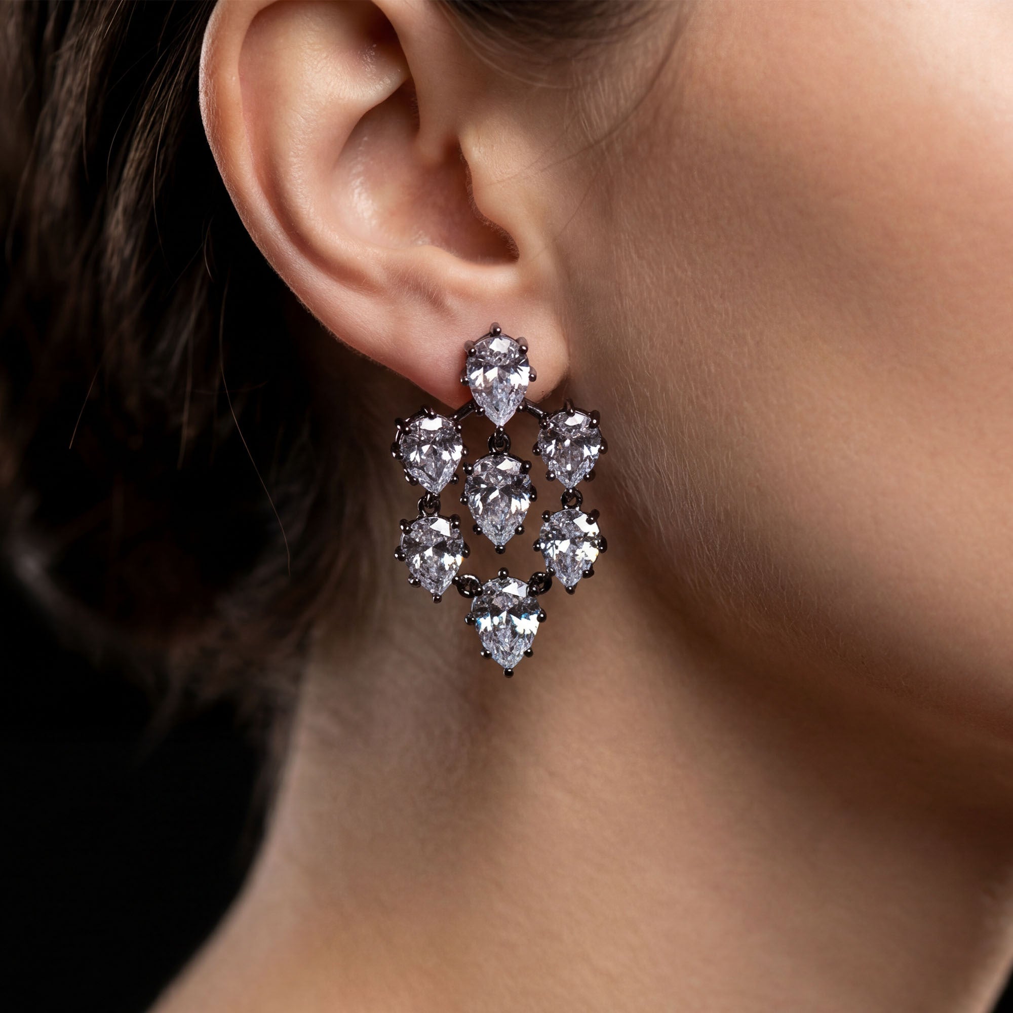 Close-up of a person wearing a sparkling diamond earring.