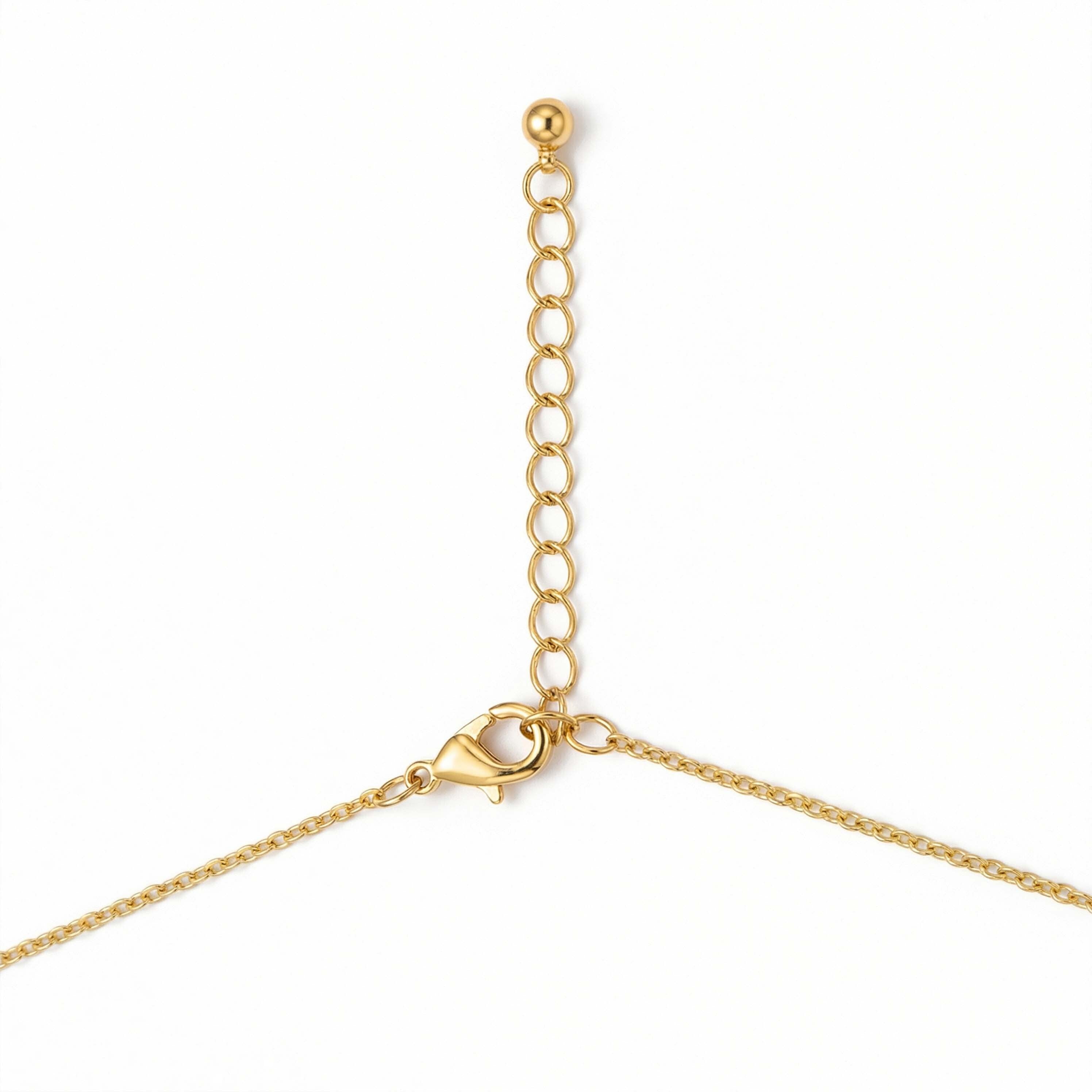 Gold chain necklace with a heart clasp on a white background