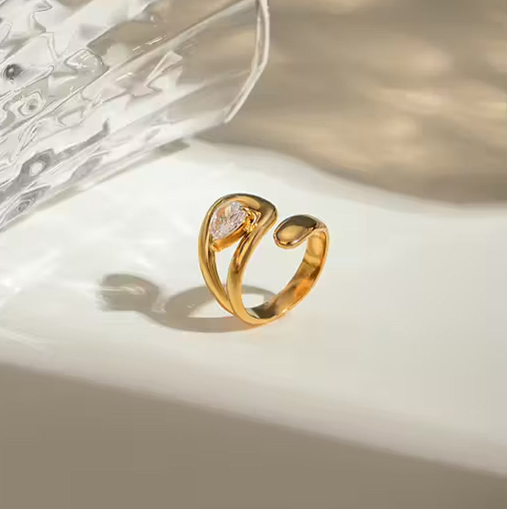 Gold ring with a central gemstone on a white surface