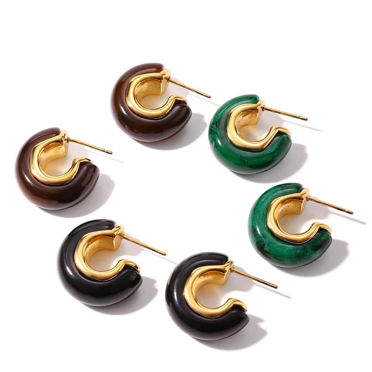 Set of hoop earrings in gold, brown, green, and black on a white background