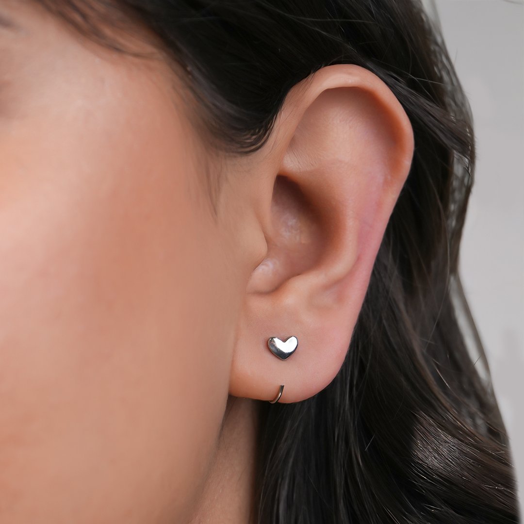 Heart-shaped earrings for women worn by a person with dark hair.