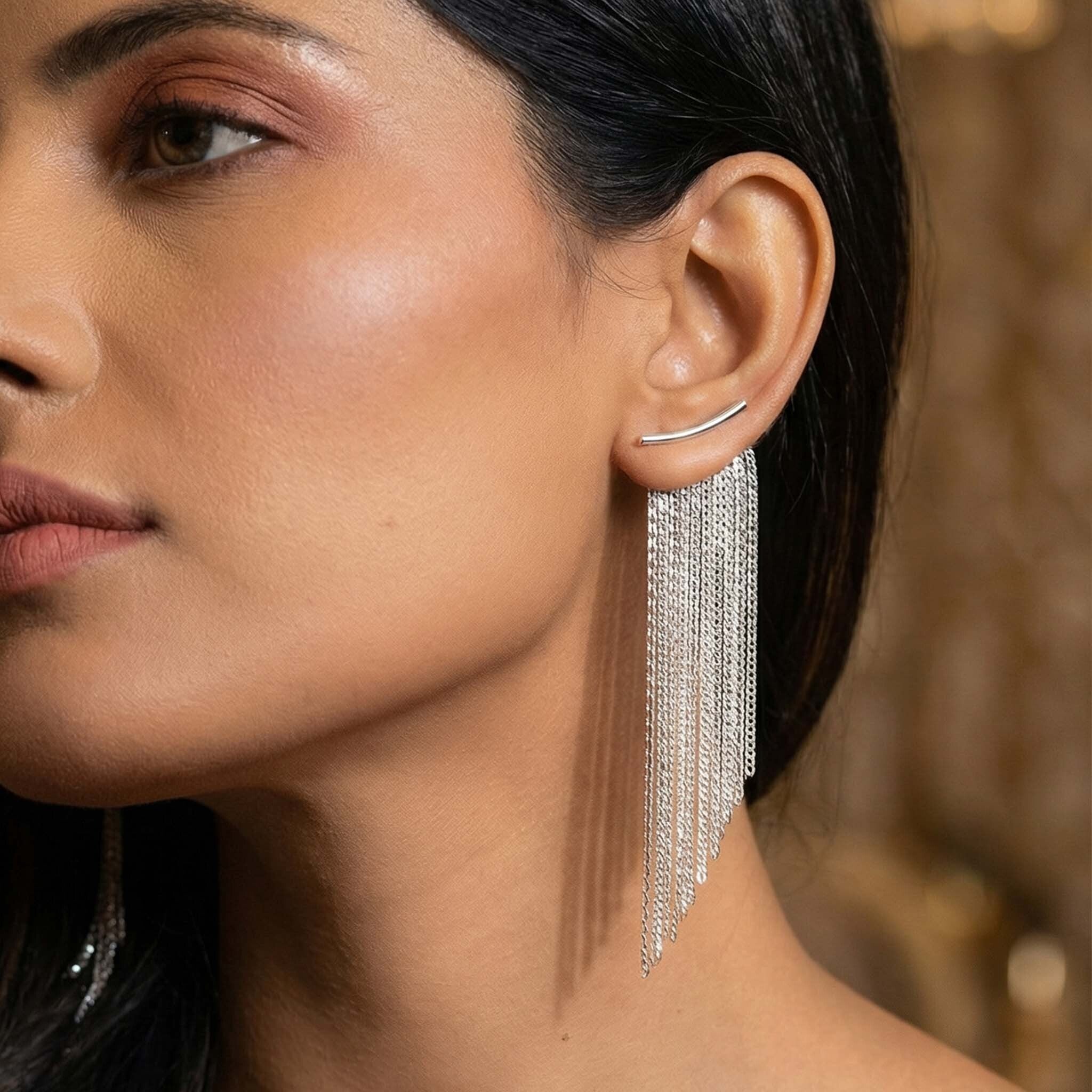 Close-up of a woman wearing a silver earrings for women with dangling chains.