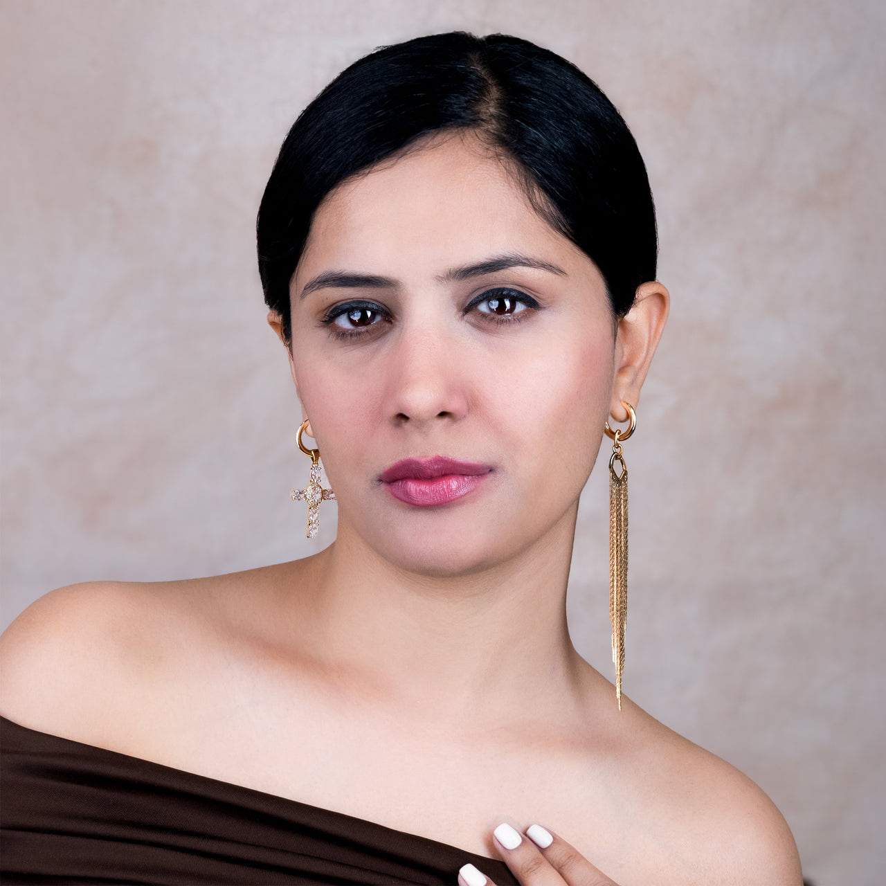 Woman wearing gold earrings  for women against a neutral background