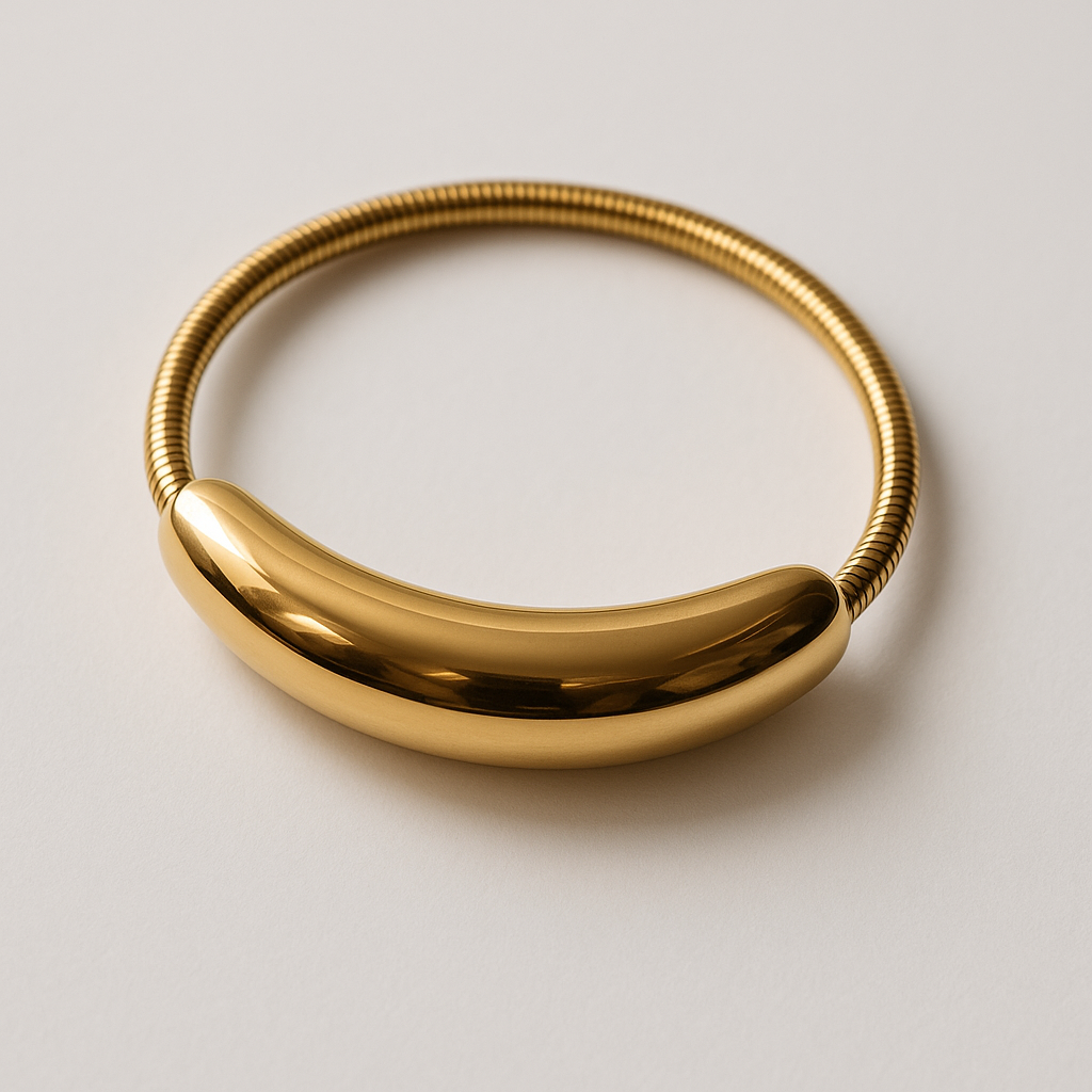 Gold bracelet on a light gray 