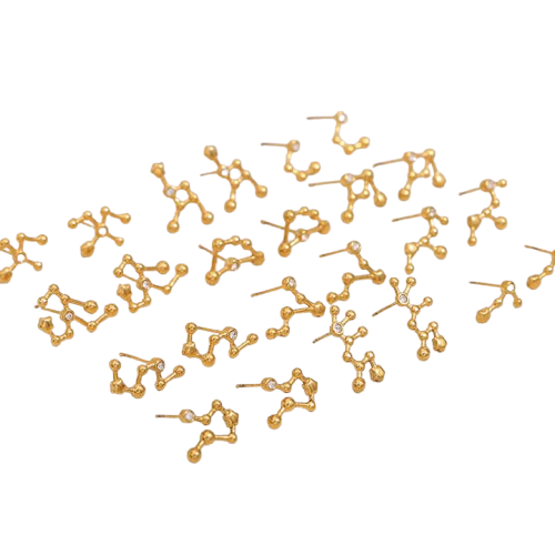 Gold Zodiac Stud  earrings scattered on a white background