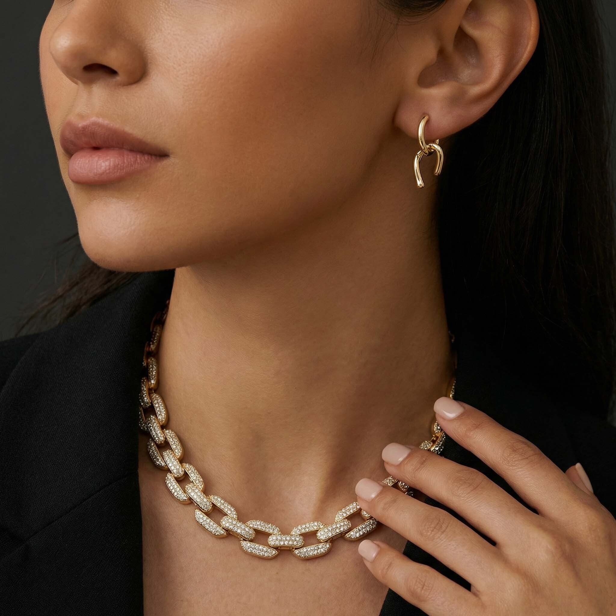 Close-up of a woman wearing gold hoop earrings and a diamond necklace for women.
