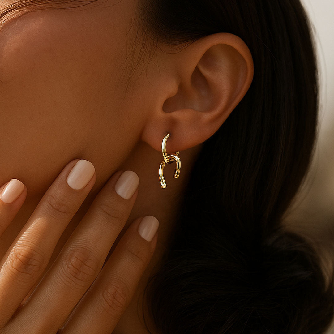 Close-up of a gold earrings for women worn by a person with a blurred background
