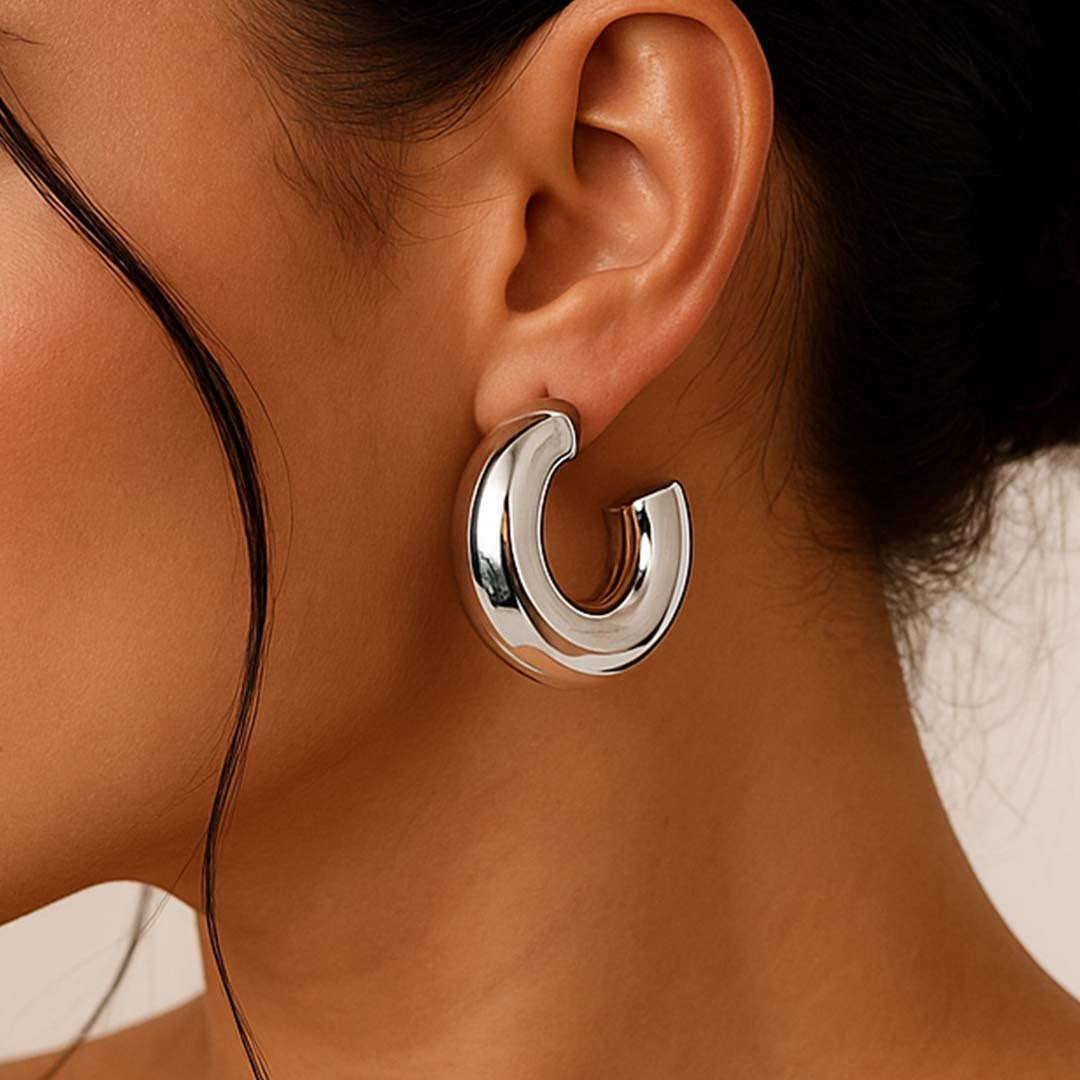 Close-up of a silver hoop earring worn by a person.