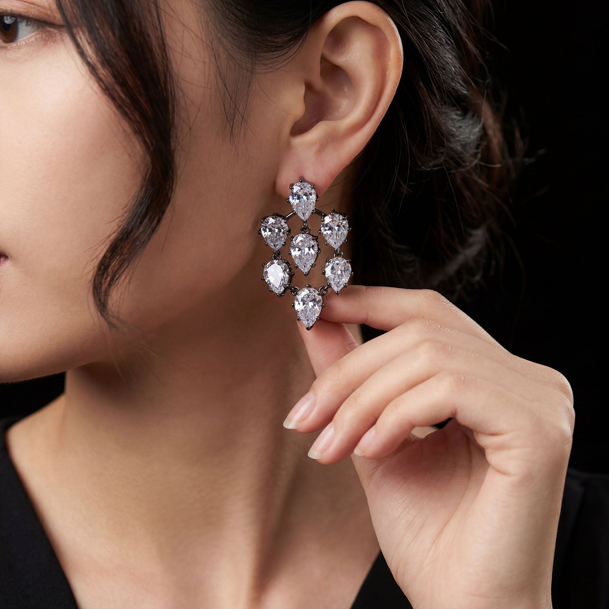 Close-up of a woman wearing a sparkling earrings for women with a hand adjusting it.