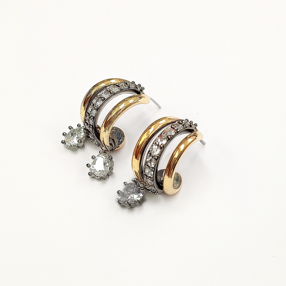 Pair of gold and silver hoop earrings with embedded diamonds on a white background