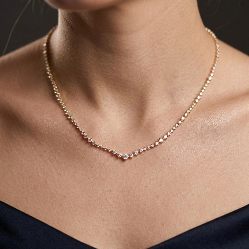 Necklace with small diamonds on a person's neck against a dark background
