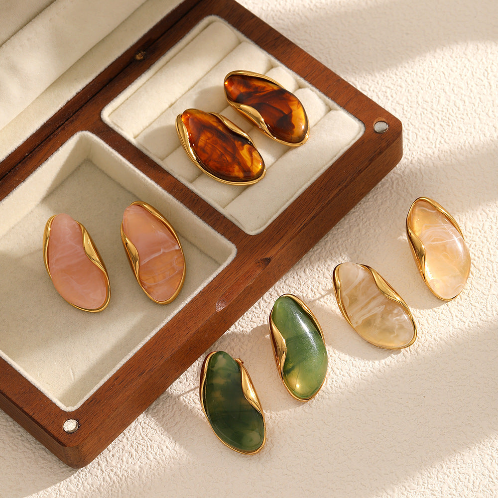 Set of gold-trimmed gemstone earrings for women in a wooden display case.