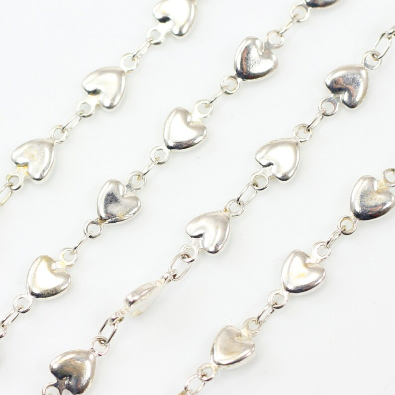 Silver heart-shaped strap on a white background
