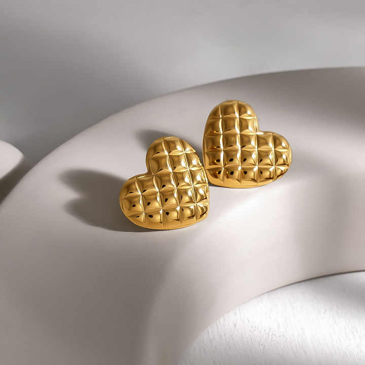 Gold heart-shaped earrings for women  on a light gray background