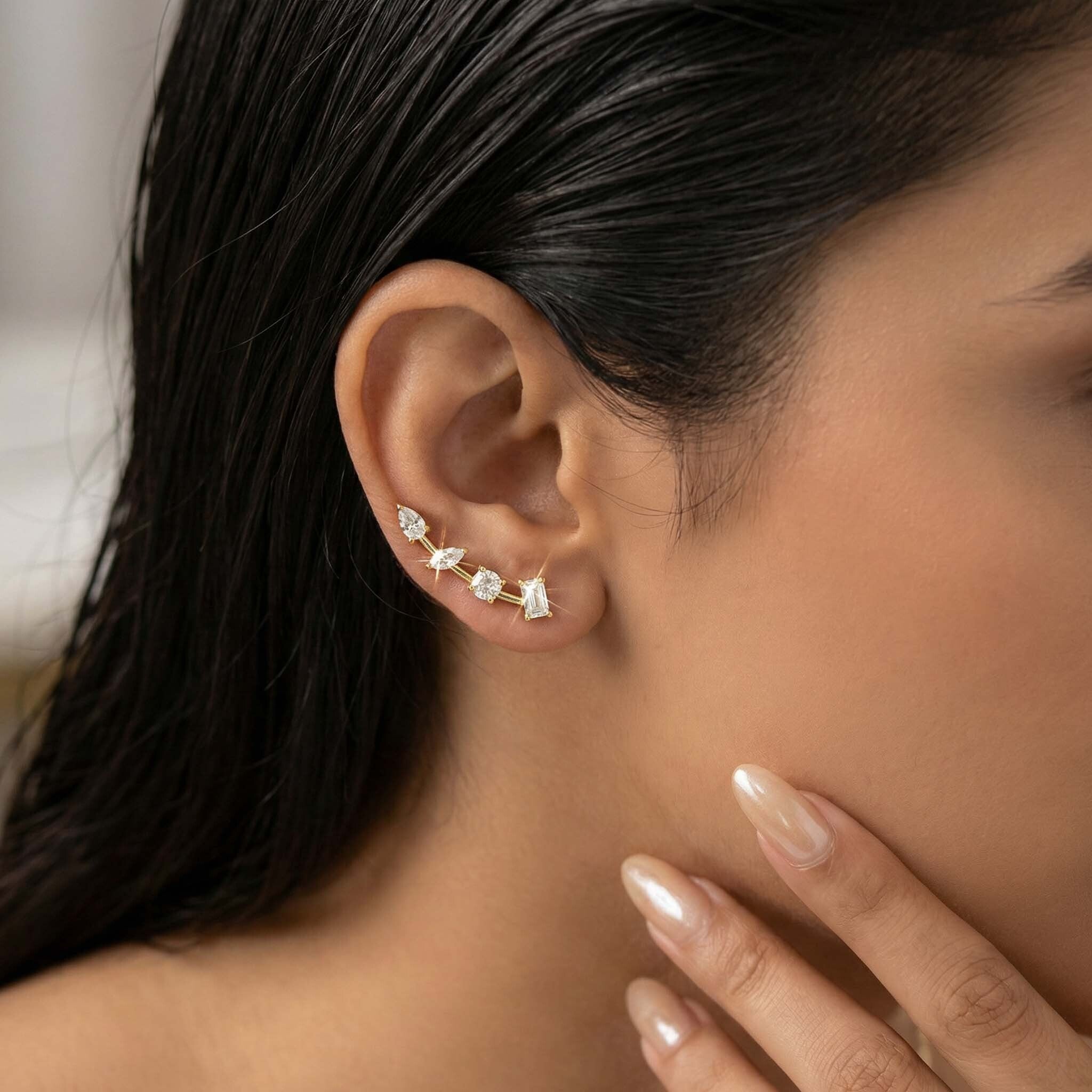 Close-up of a woman's ear wearing a diamond earring with a blurred background