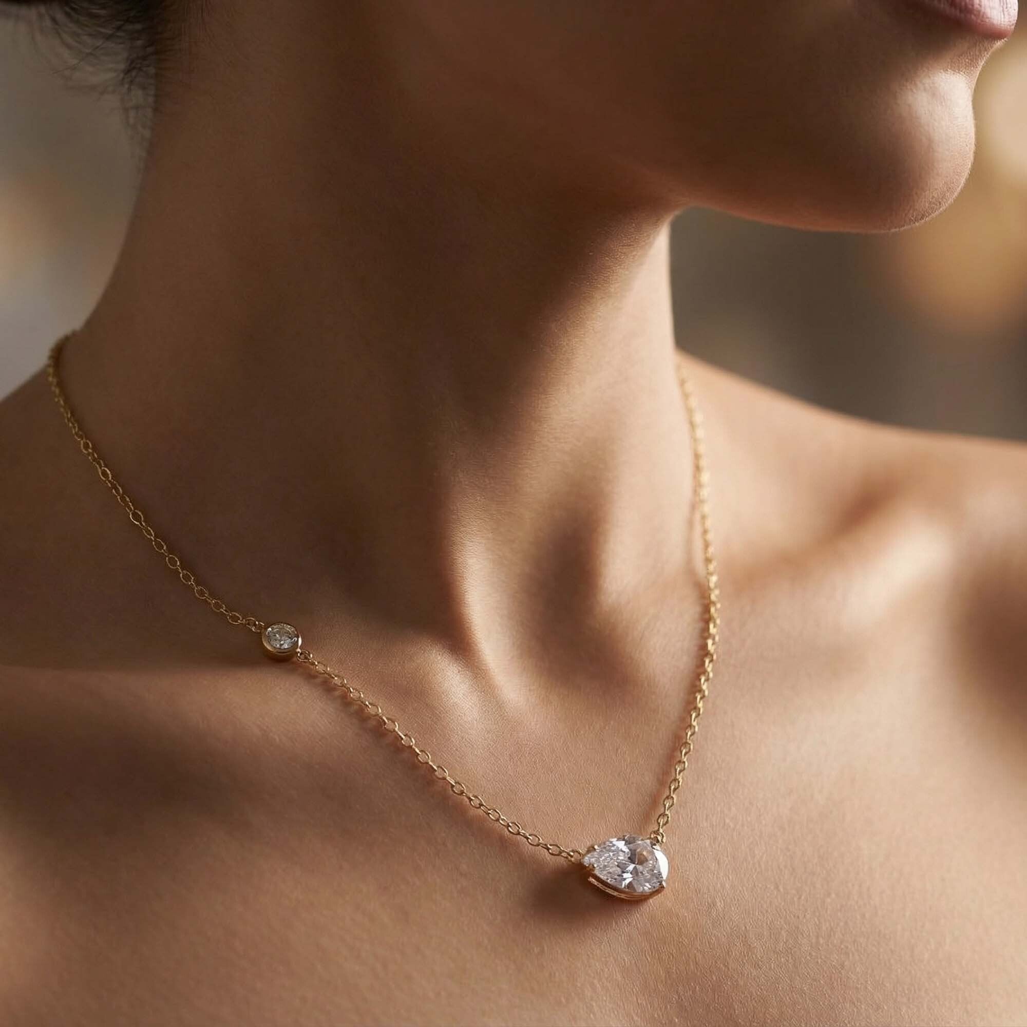 Close-up of a gold necklaces for women with a diamond pendant on a blurred background
